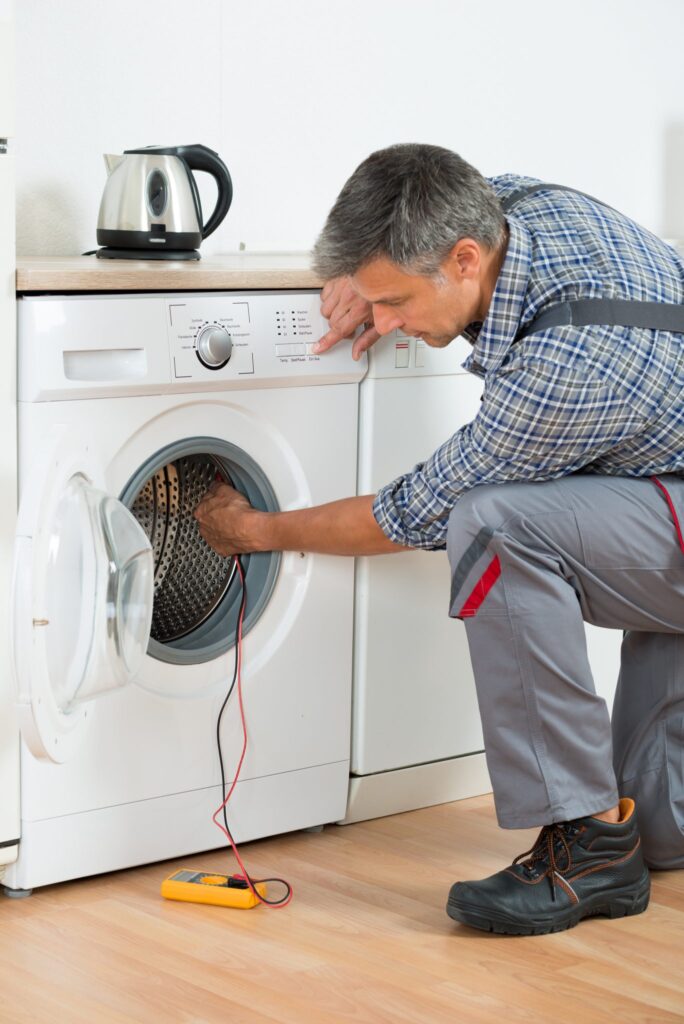 a man working on a washing machine.