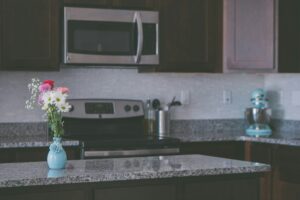 A kitchen counter with a vase of flowers.