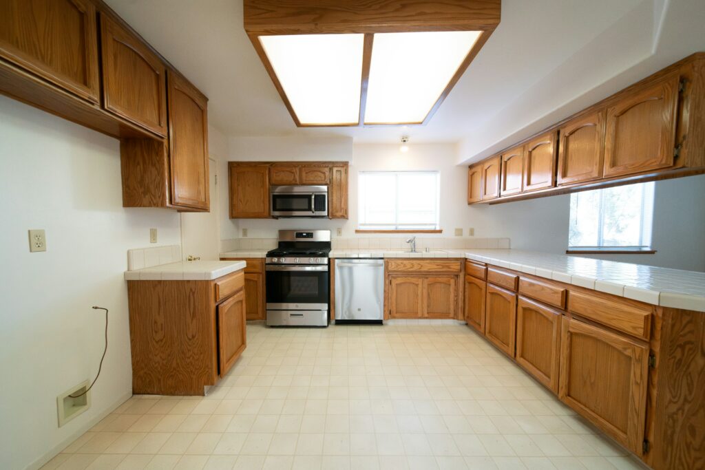 A kitchen with wood cabinets and a stove.