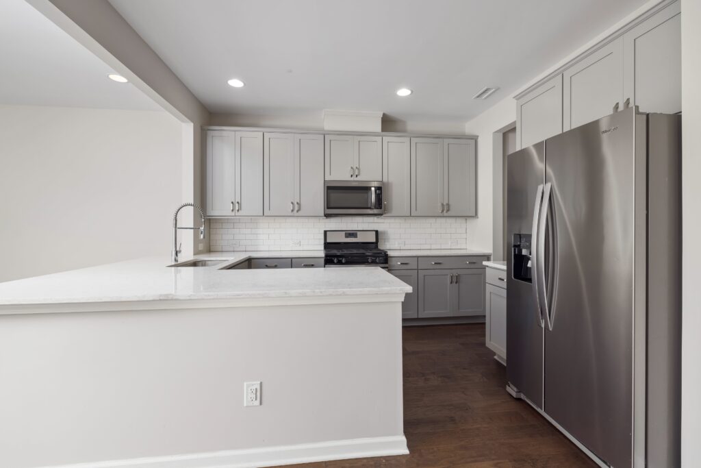 A kitchen with gray cabinets and stainless steel appliances.