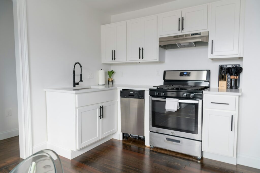a small kitchen with white cabinets and stainless steel appliances.