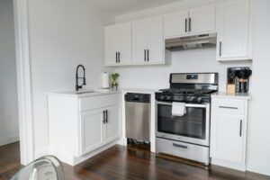 a small kitchen with white cabinets and stainless steel appliances.