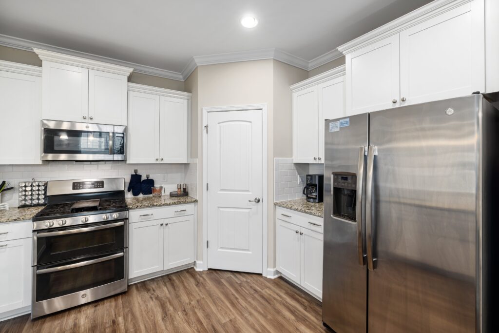 A kitchen with white cabinets and stainless steel appliances.
