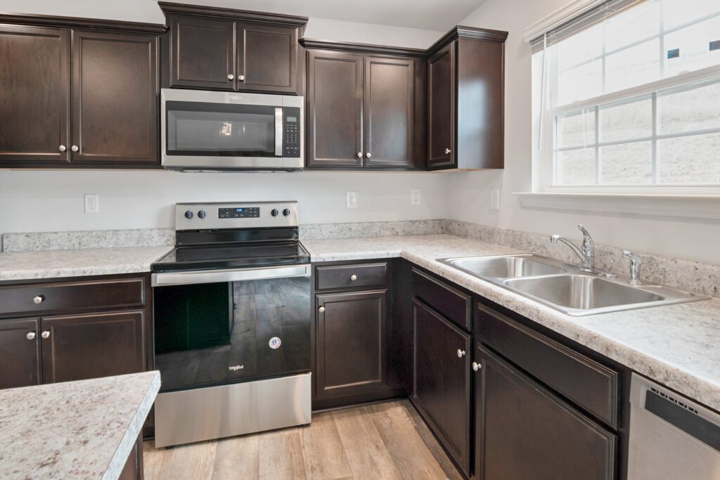 A kitchen with brown cabinets and stainless steel appliances.