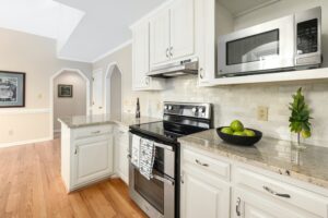 A kitchen with white cabinets and stainless steel appliances.