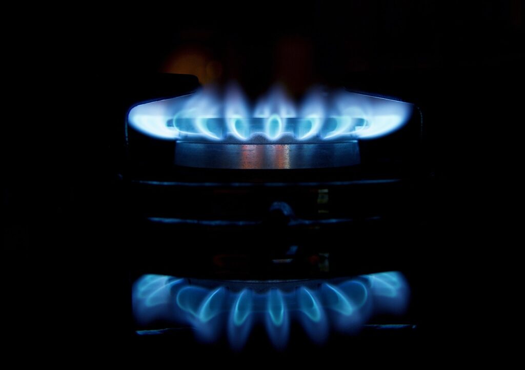 A gas stove with blue flames in the dark.