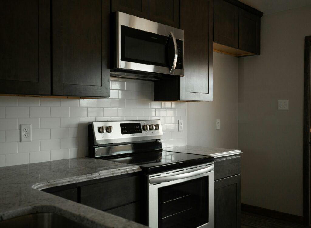 a kitchen with stainless steel appliances and black cabinets.