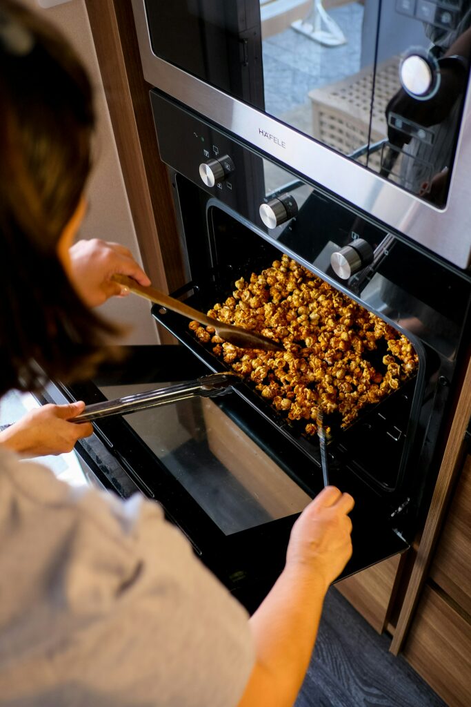 a woman removing food from an oven.