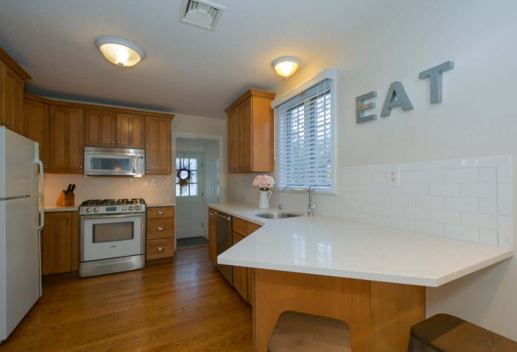a kitchen with wood cabinets and a white counter top.