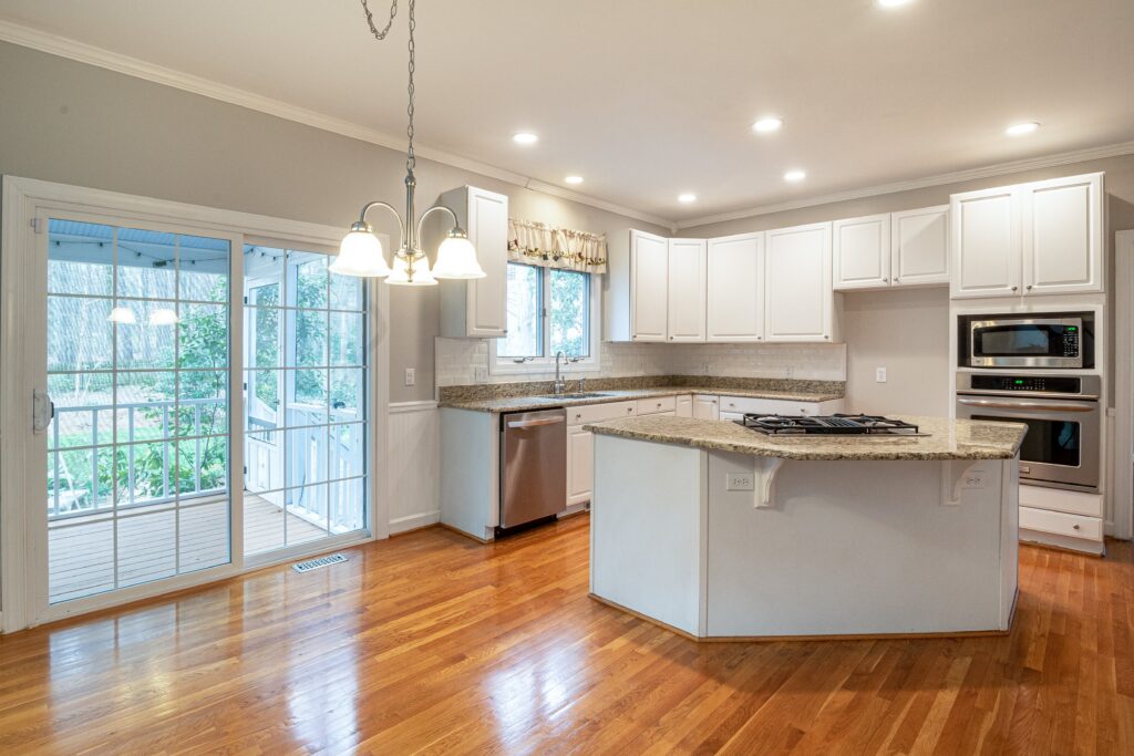 a kitchen with hardwood floors and a sliding glass door.