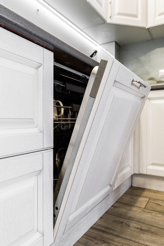 an open dishwasher in a white kitchen.