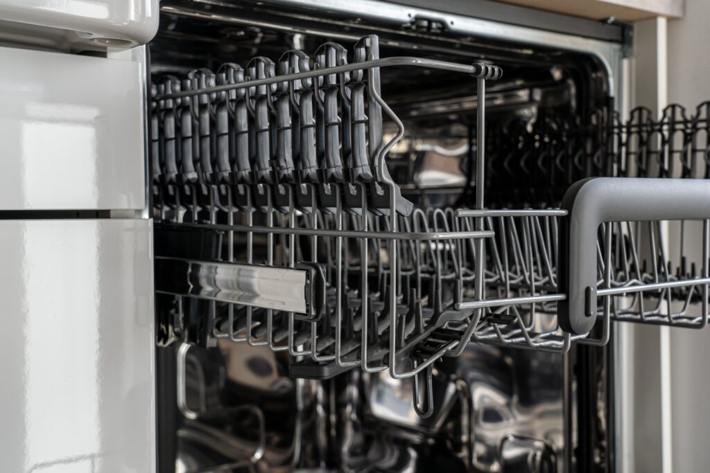 a close up of a dishwasher with metal racks.