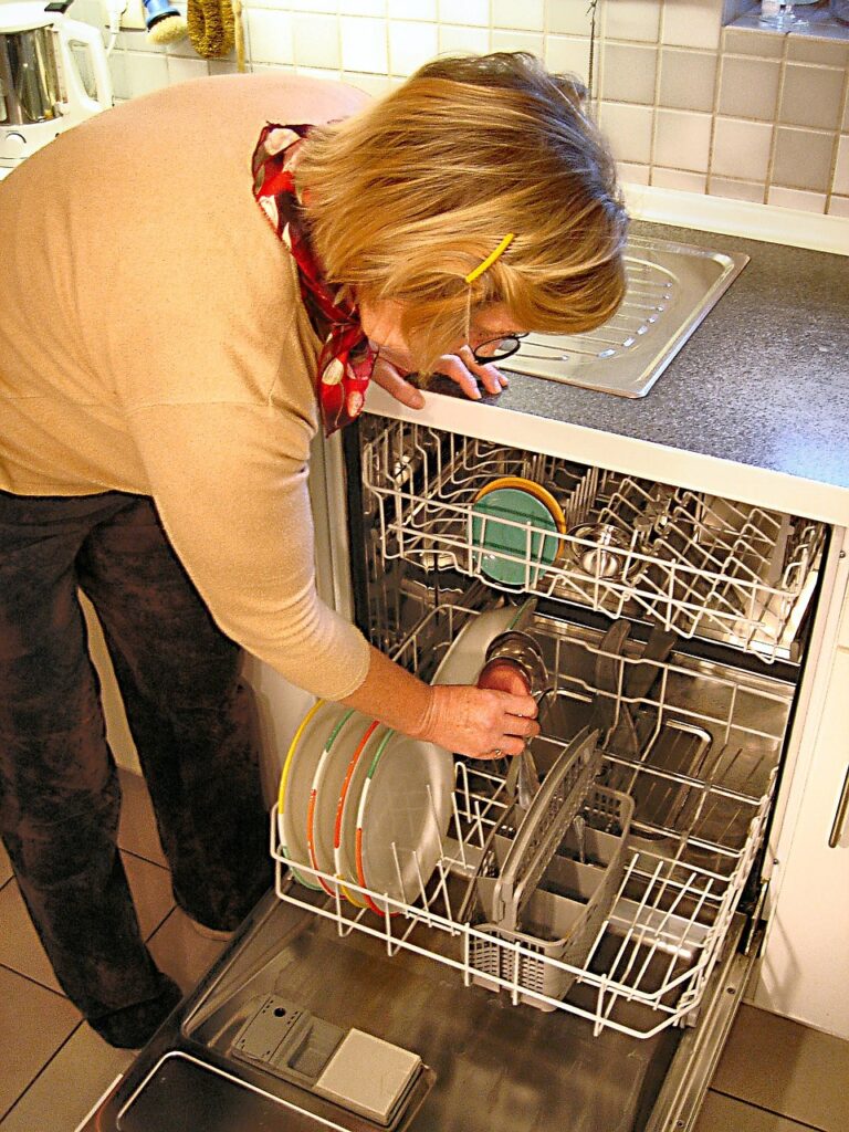 a woman opening a dishwasher.