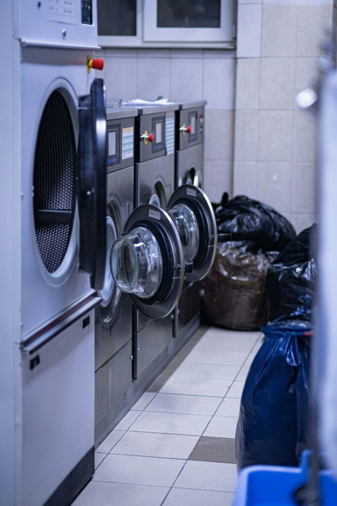 a row of washing machines in a laundry room.