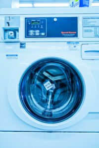 a white washing machine in a laundry room.
