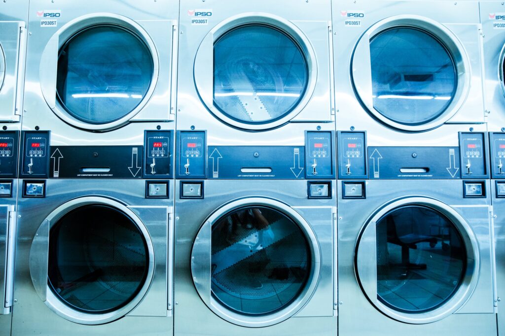 a row of washers and dryers in a laundry room.