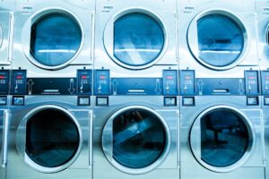 a row of washers and dryers in a laundry room.