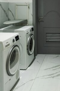 a laundry room with two washing machines and a door.