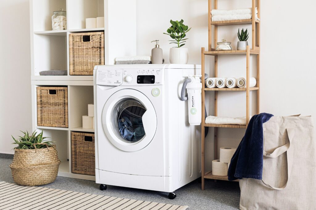 a laundry room with a washing machine and baskets.
