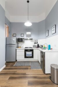 a small kitchen with blue walls and wooden floors.