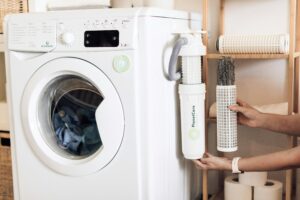 a woman is standing next to a washing machine.