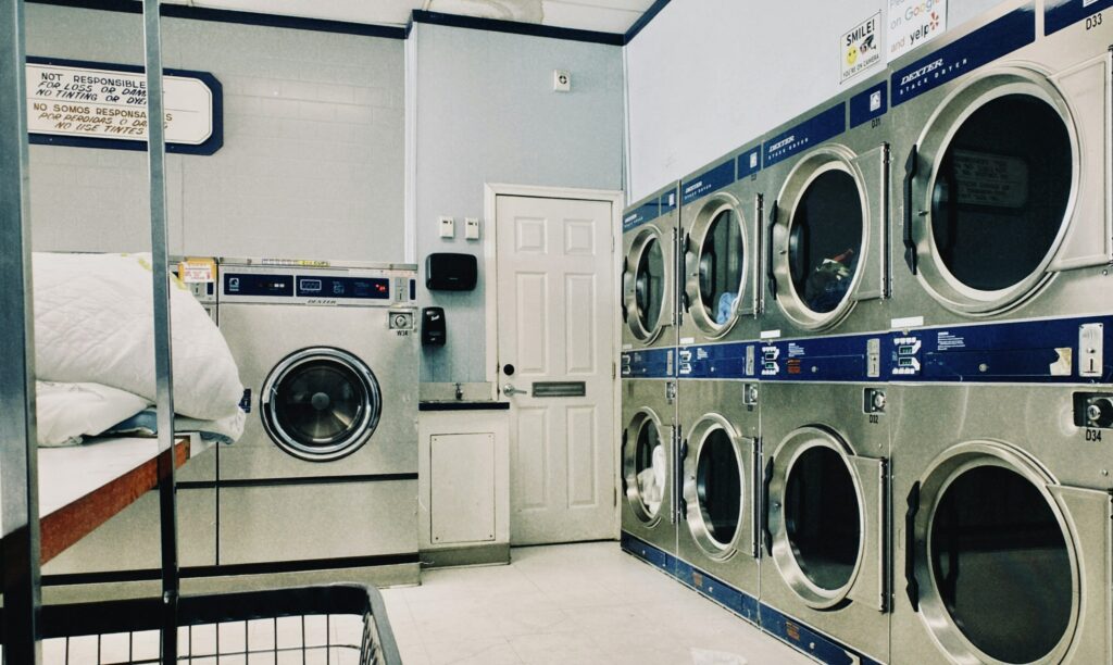 A laundry room with many washing machines.