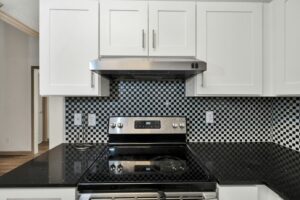 A black and white kitchen with a stove and oven.