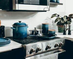 A kitchen with blue pots and pans on the stove.