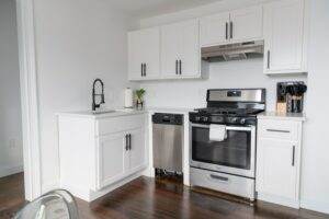 A small kitchen with white cabinets and stainless steel appliances.