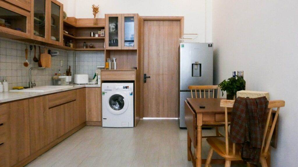 A small kitchen with wooden cabinets and a washing machine.