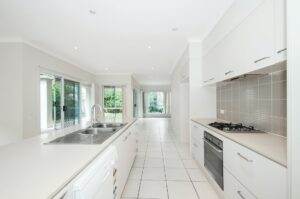 A white kitchen with a sink and a dishwasher.
