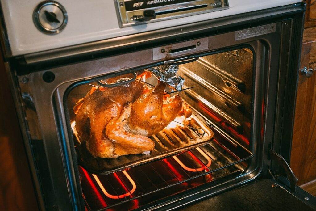 A turkey is cooking in an oven.