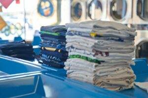A stack of t - shirts in a laundry room.