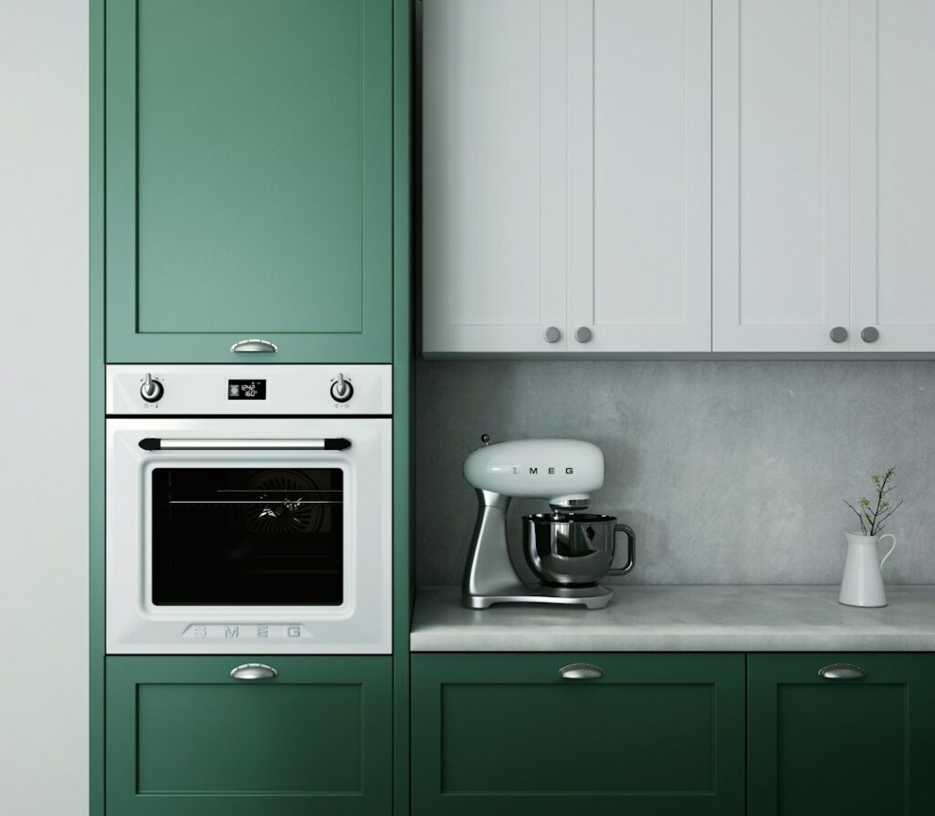a kitchen with green cabinets and white appliances.