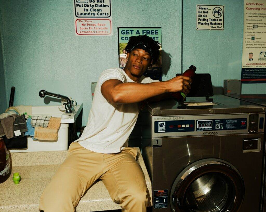 A man sitting on top of a washing machine.